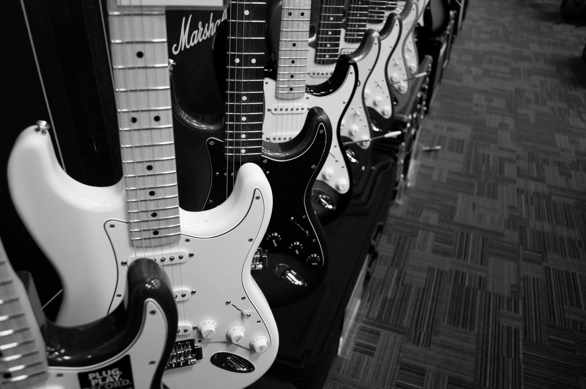 A row of guitars lined up in a line.